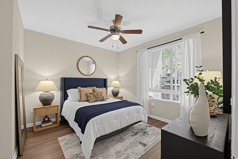 A bedroom with a bed, a ceiling fan, and a window with blinds.