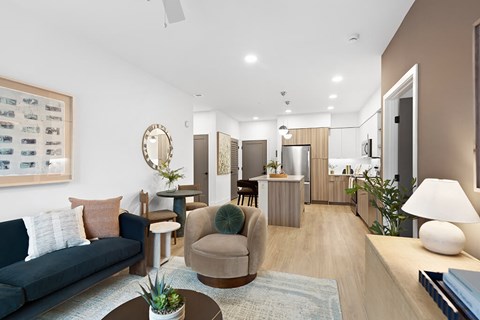 A living room with a couch, chair, and a table with a plant on it.