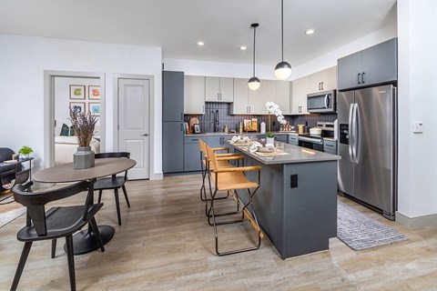 A modern kitchen with a dining table and chairs.