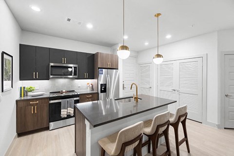 a kitchen with a large island with three chairs