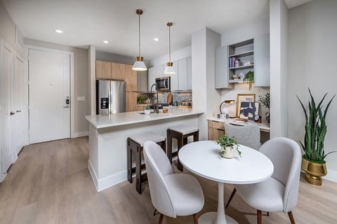 A modern kitchen with a dining table and chairs.