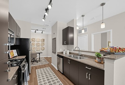 A modern kitchen with dark brown cabinets and a black refrigerator.
