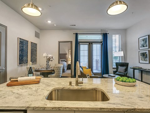 a kitchen counter with a sink and a living room
