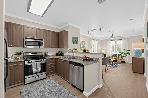 A modern kitchen with brown cabinets and stainless steel appliances.