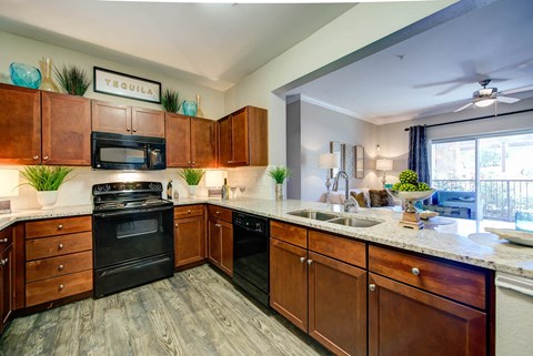a large kitchen with wooden cabinets and black appliances
