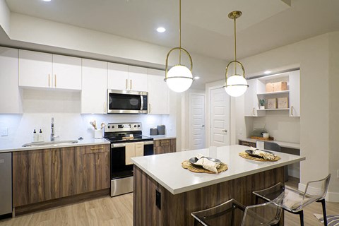 a kitchen with an island and a stove and a microwave