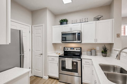 a kitchen with stainless steel appliances and white cabinets