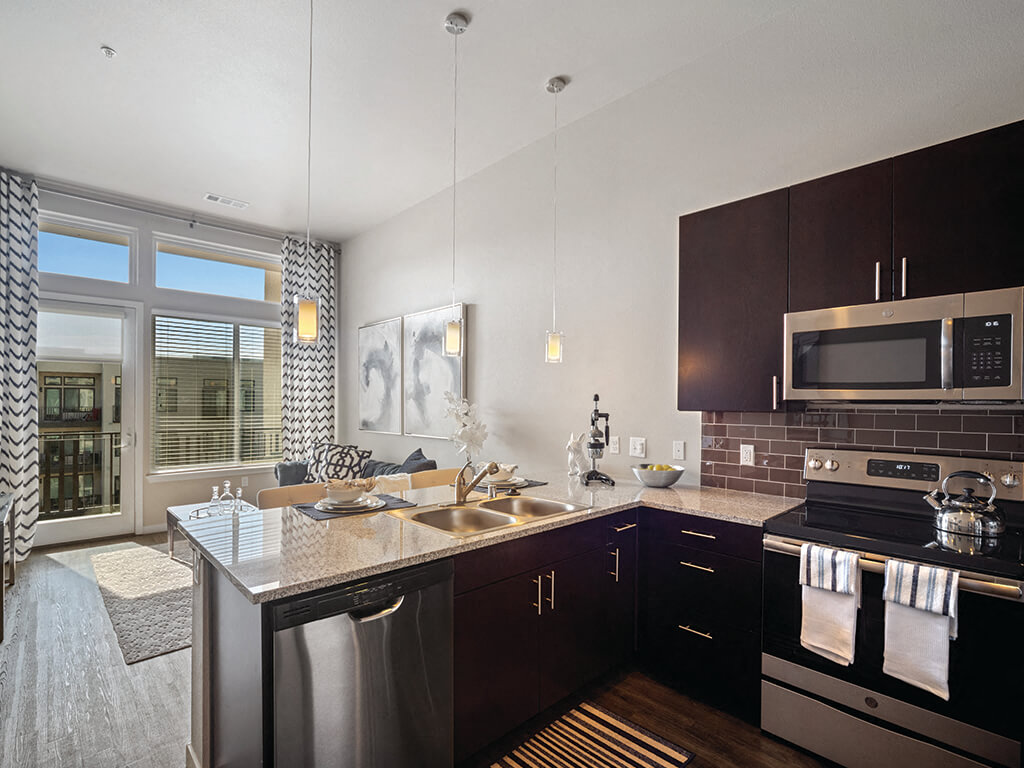 A modern kitchen with dark wood cabinets and stainless steel appliances.