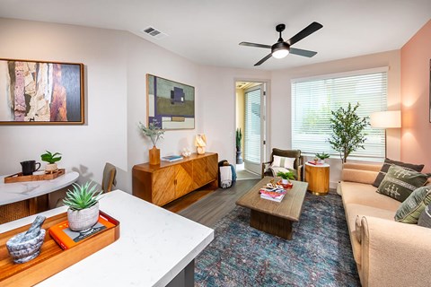 A living room with a white table and a blue rug.