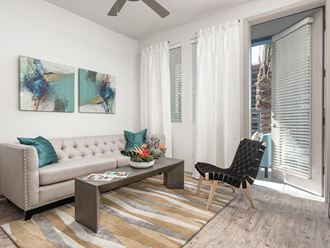 a living room with white walls and a sliding glass door at Norte Town Lake Apartments in Tempe Arizona