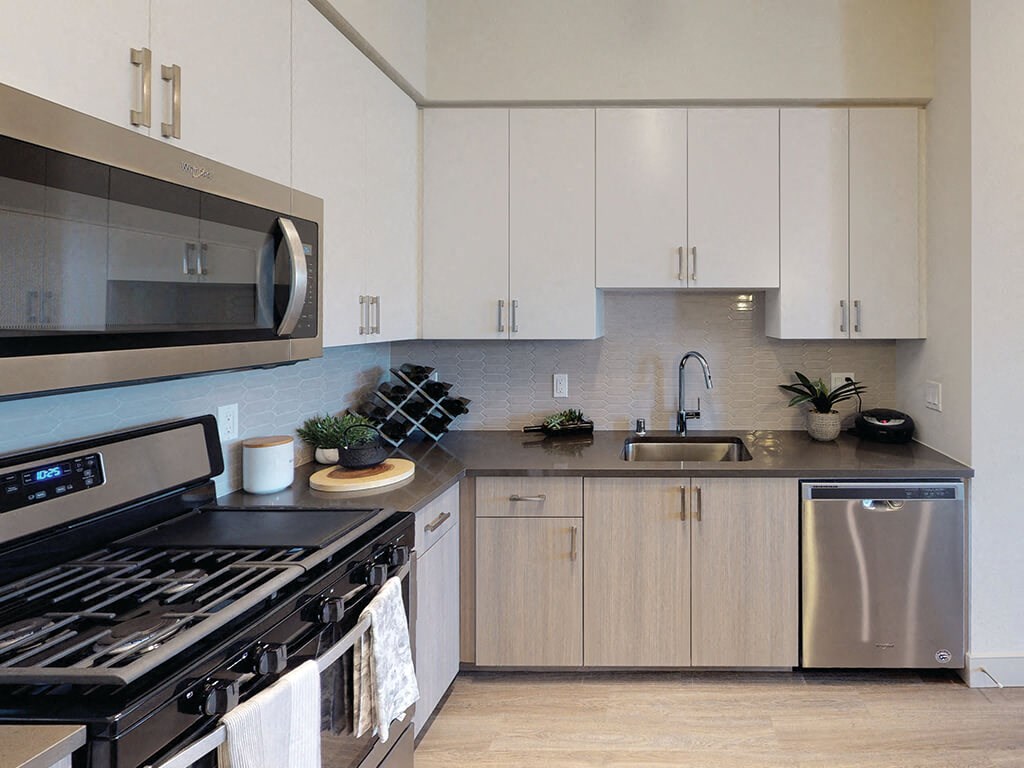 a kitchen with white cabinets and stainless steel appliances