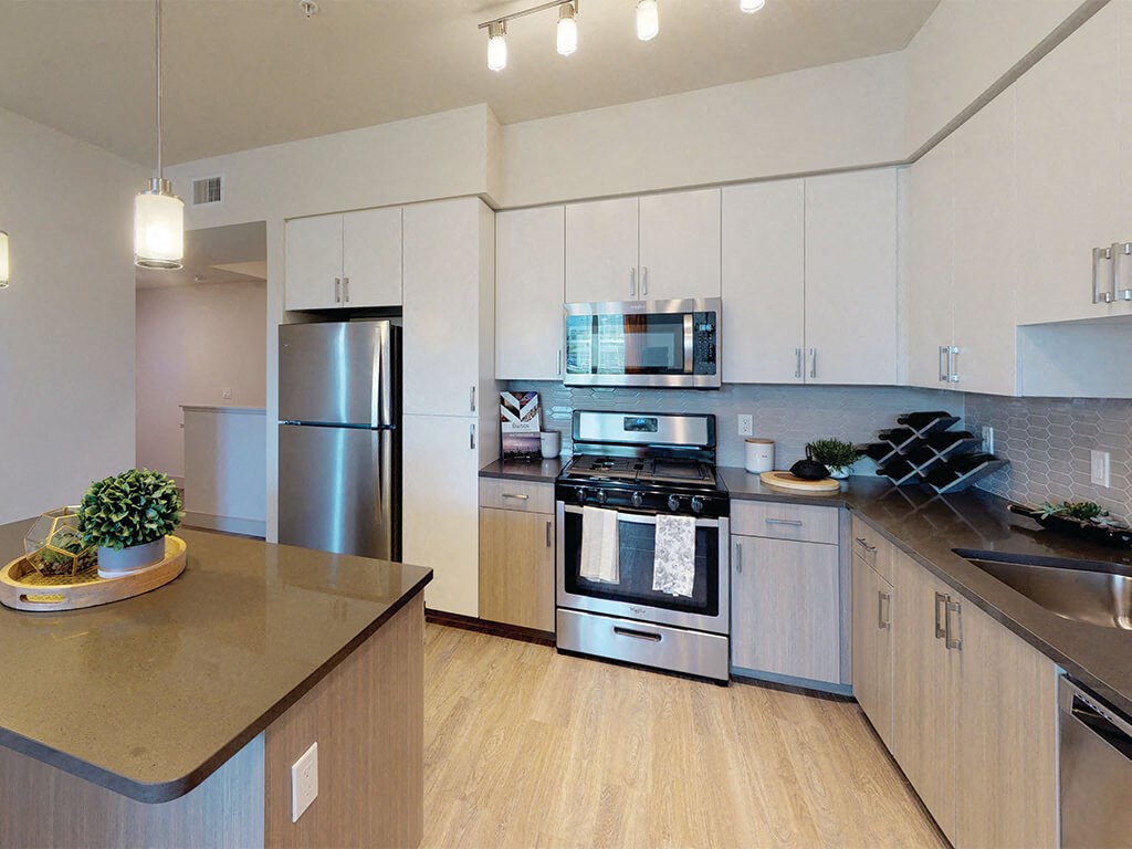 a kitchen with white cabinets and stainless steel appliances