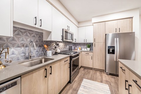 a modern kitchen with stainless steel appliances and wooden cabinets
