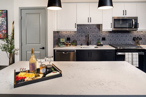 a kitchen counter with a tray of food and a bottle of wine