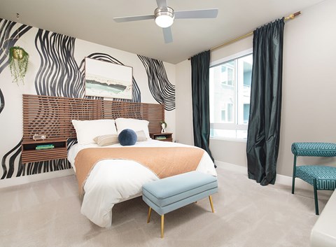 A bedroom with a zebra print wallpaper and a bed with a wooden headboard.