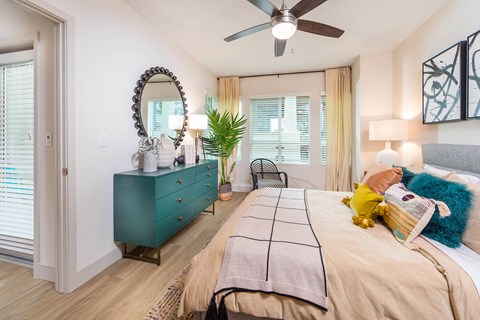 Sepia Design Package Bedroom with ceiling fan and large window at The Seaton Apartments in San Diego CA