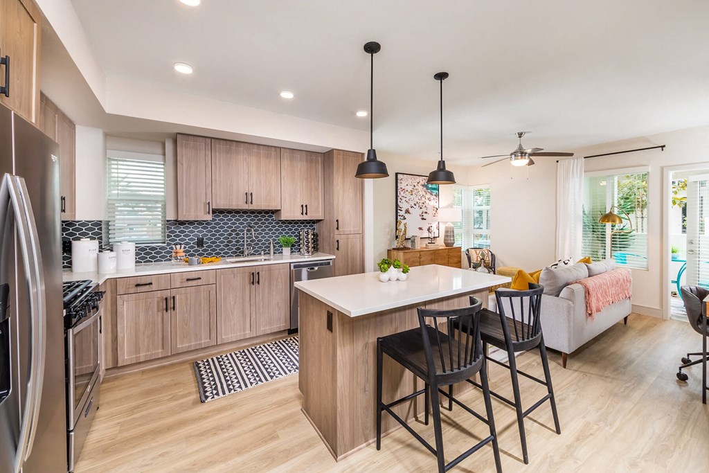 Sepia Design Package Kitchen with island seating and light wood cabinets at The Seaton Apartments in San Diego CA
