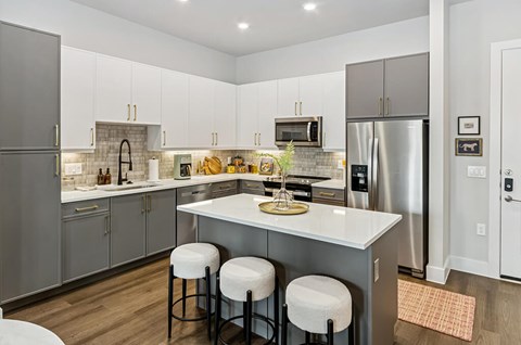 A kitchen with a white counter top and stainless steel appliances.