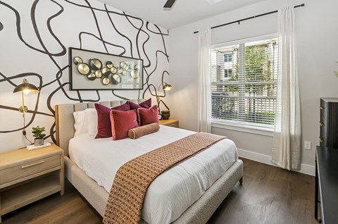 A bedroom with a large bed and a wall art.