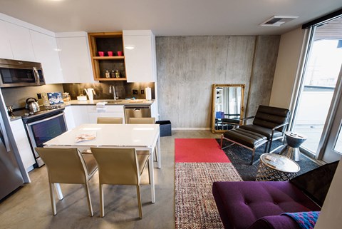 a kitchen and living room with a table and chairs