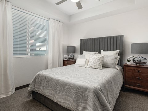 Bedroom with ceiling fan and window at Norte Town Lake Apartments in Tempe Arizona