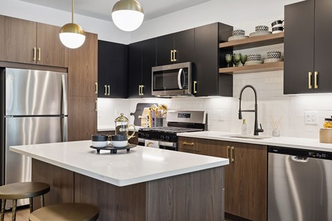 a kitchen with stModel kitchen appliances at Jayden Apartments in Peabody MAainless steel appliances and black cabinets