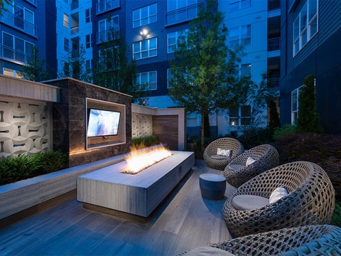 an outdoor living area with a fire pit and a television