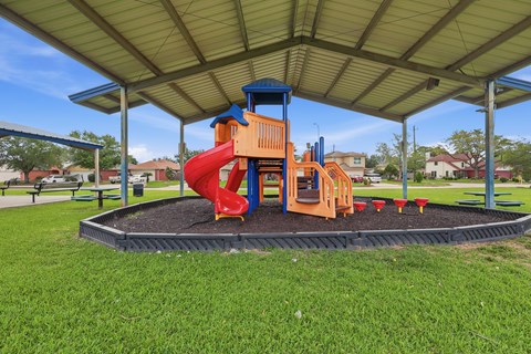 A playground with a red slide and a blue and orange structure.