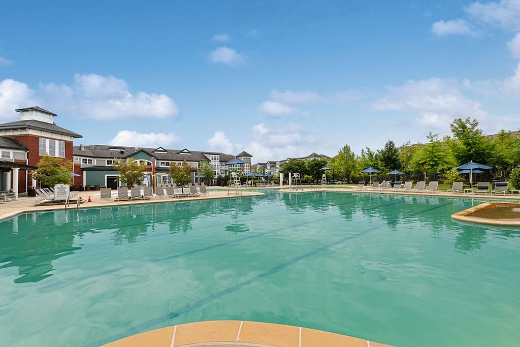 a large swimming pool with apartments in the background
