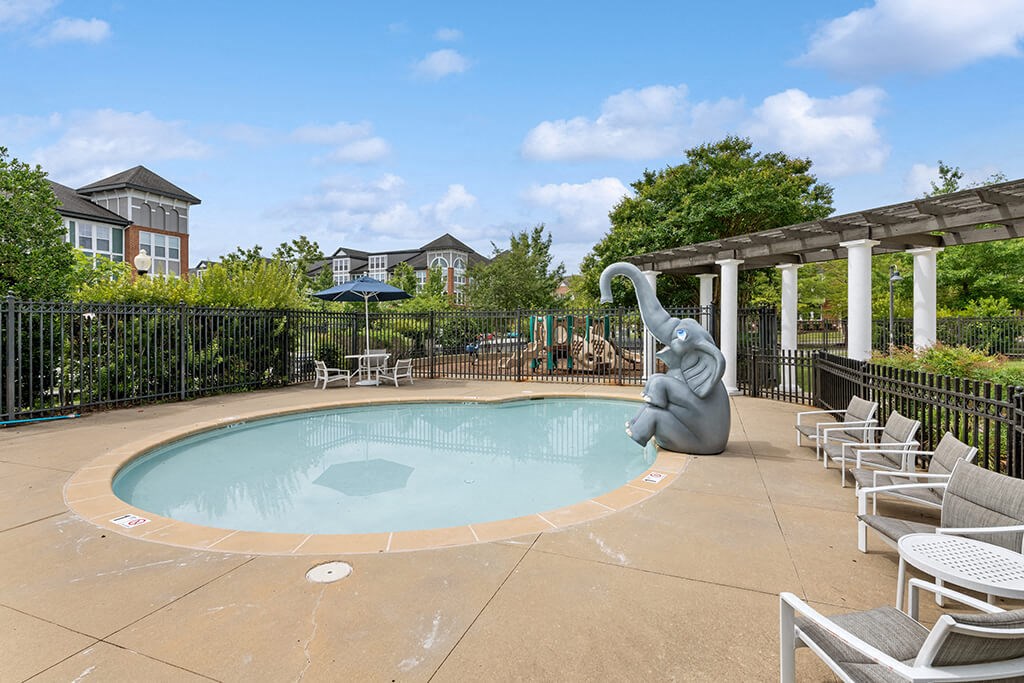 a swimming pool with an elephant statue next to it