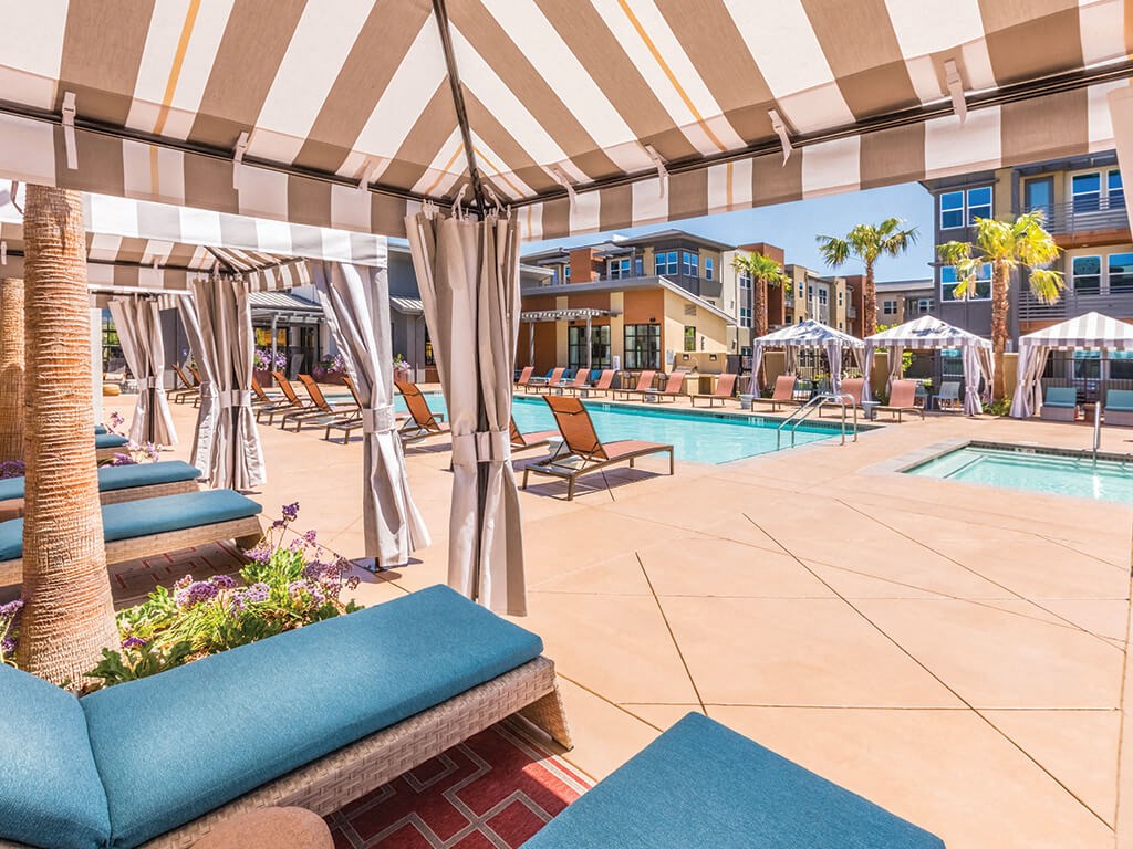 a swimming pool with lounge chairs and umbrellas