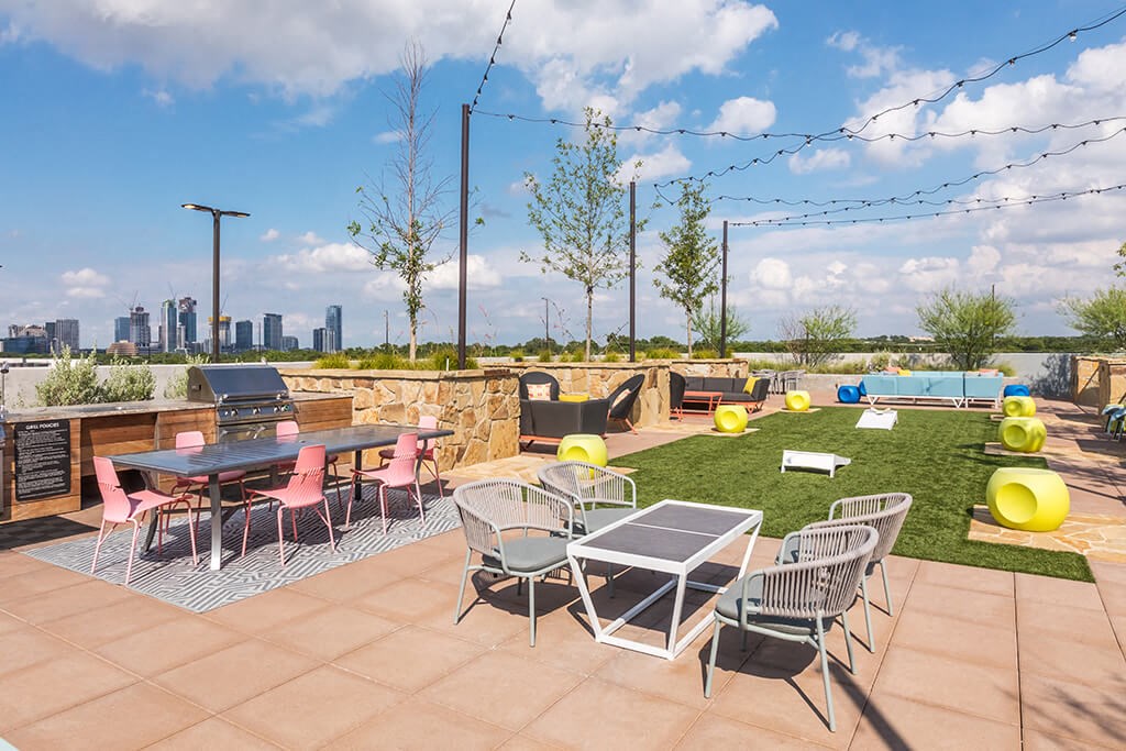 a rooftop patio with tables and chairs and a view of the city