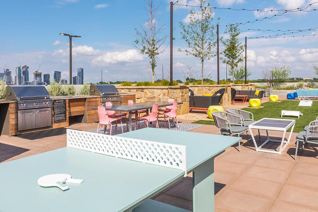 a patio with tables and chairs and a city in the background