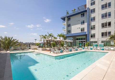 A large swimming pool in front of a multi-story building.