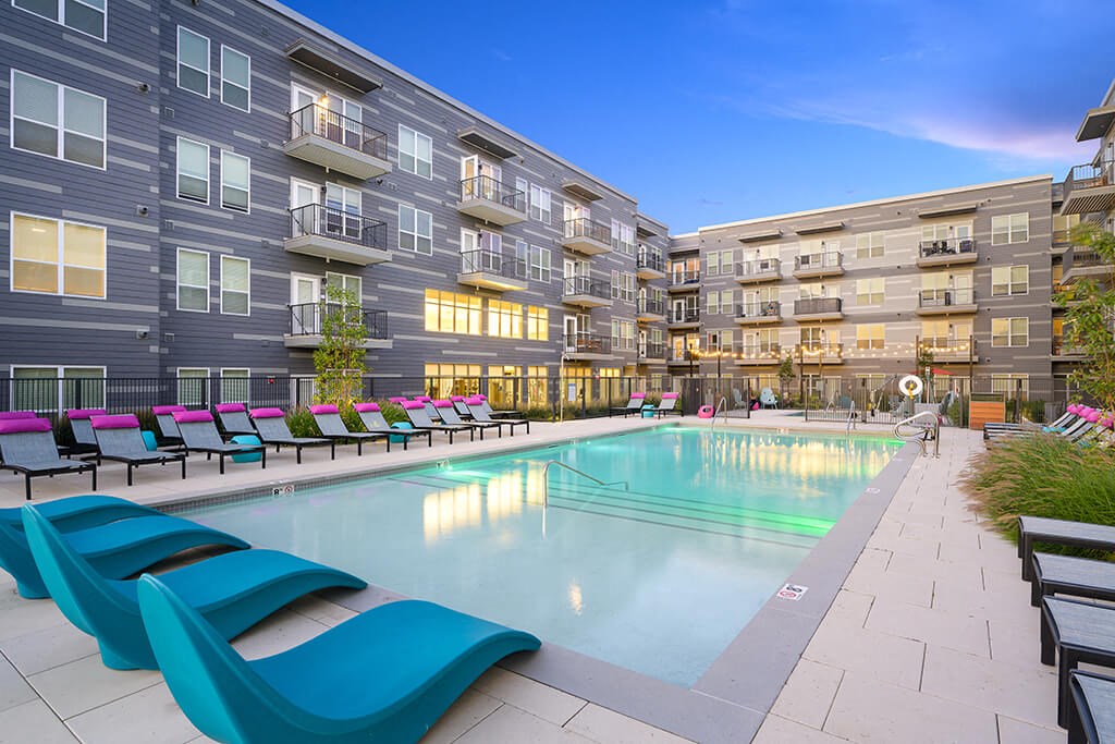 a swimming pool in front of some apartment buildings