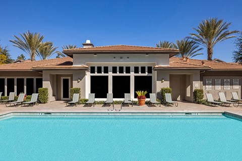 A large house with a pool in front.