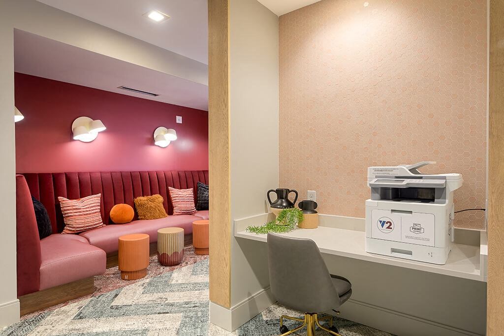 a waiting room with a pink couch and a printer