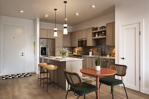 A kitchen with a table and chairs in the foreground and a bar area in the background.