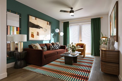 A living room with a red couch and a striped rug.