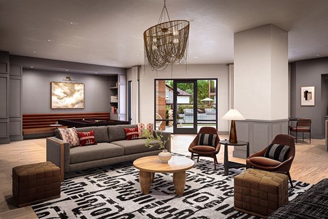 A living room with a grey couch, two chairs, a coffee table, and a rug with a black and white pattern.