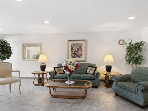 a living room with couches and chairs and a table with flowers