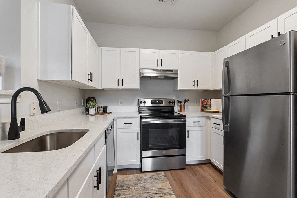 a kitchen with stainless steel appliances and white cabinets