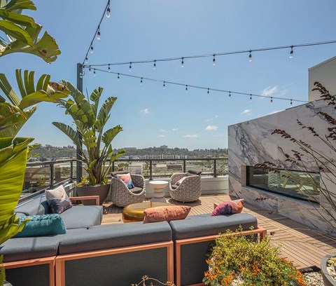 A patio with a couch, chairs, and plants.