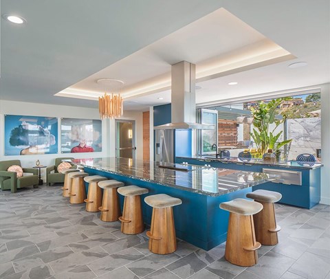 A bar with blue counter and stools.