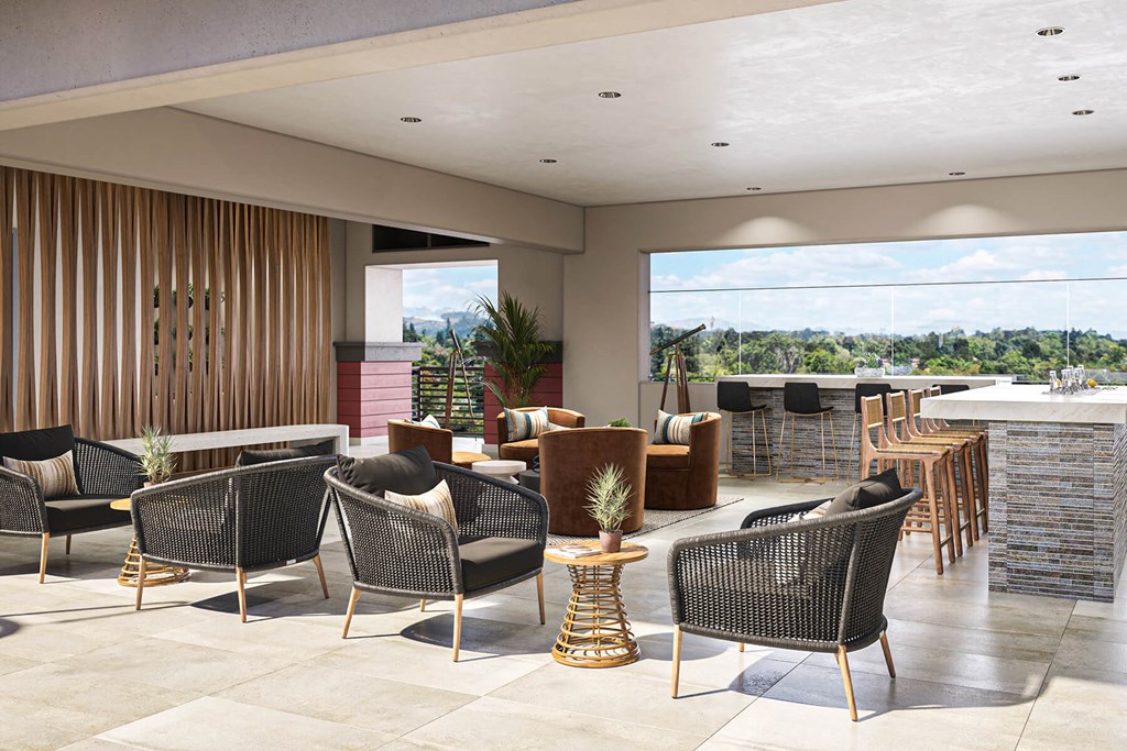 a lounge area with chairs and tables and a bar with a view of a body of water