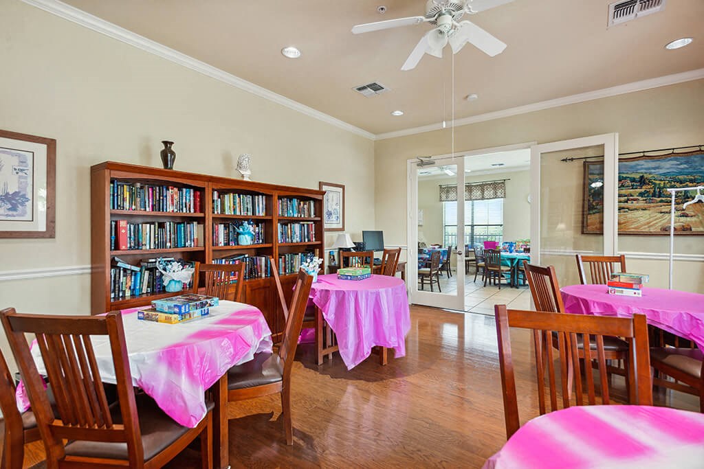 Seating and bookshelf in lounge at Parkway Senior Apartments in Pasadena TX
