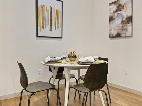 A dining room with a white table and chairs.