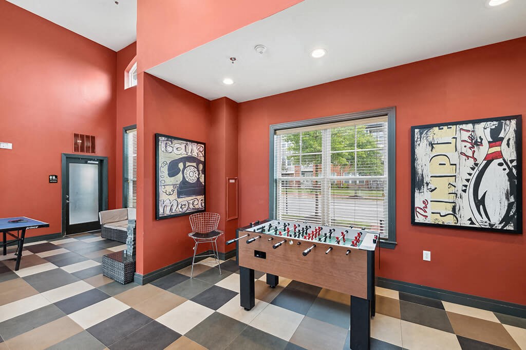 a game room with a foosball table and a window