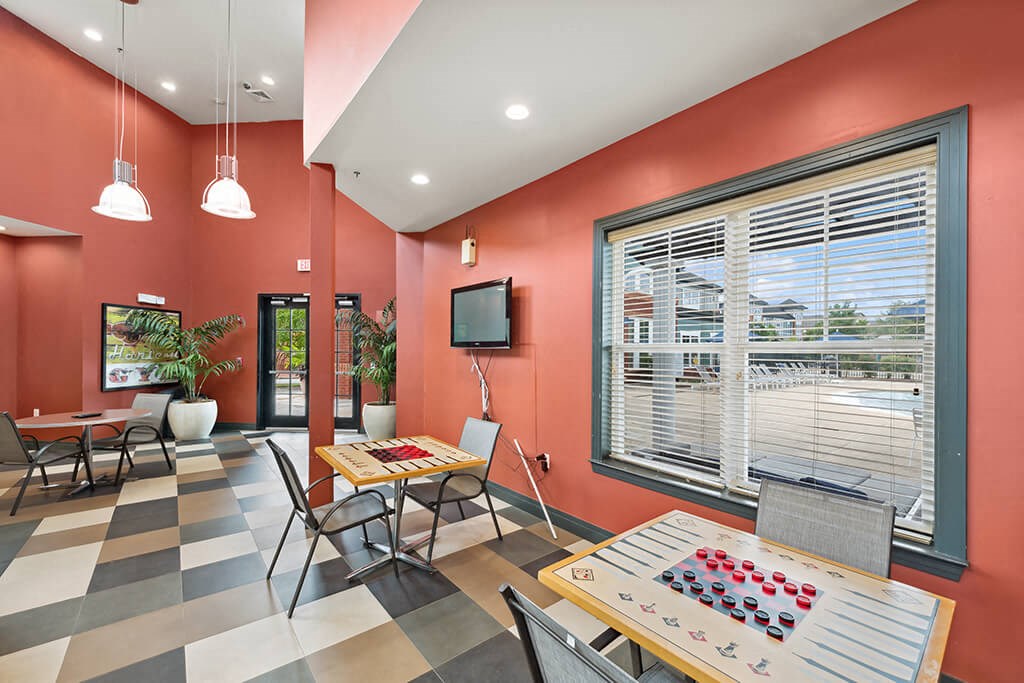 a game room with tables and chairs and a television