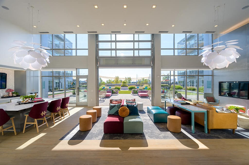 a living room filled with furniture and large windows